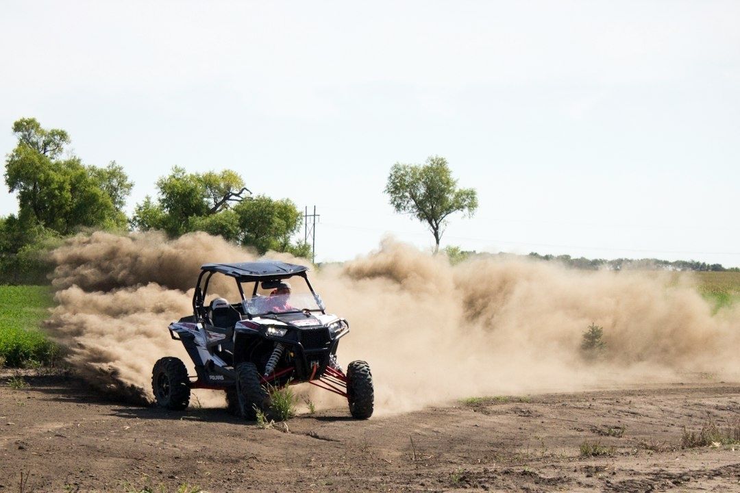 Offroadbuggy raast over een veld en veroorzaakt een grote stofwolk